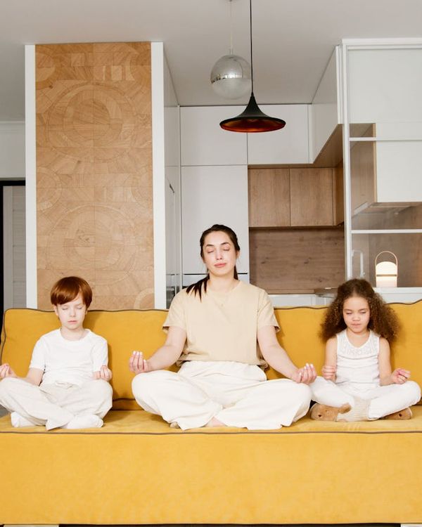 A child sitting peacefully in a simple yoga pose, eyes closed.